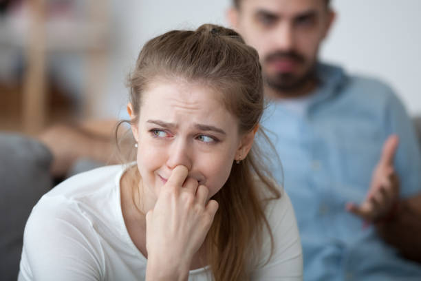 Stressed woman crying feeling depressed offended by controlling husband tyrant blaming wife of problems in unhappy marriage, sad girl in tears worried about family fight and relationships problems
