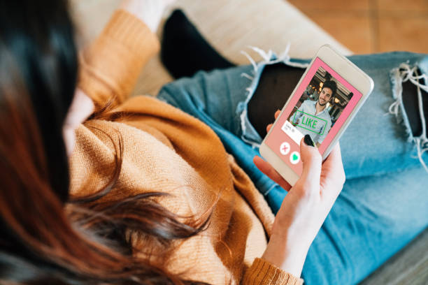 Young adult woman swiping on an online dating app. She's using her smart phone on the sofa at home. What to Watch Out For With Online Dating