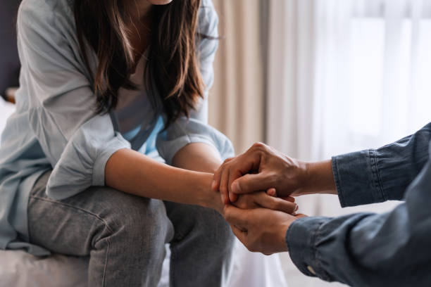 Young man comforting and supporting a sad woman he is trying to regain trust in a marriage