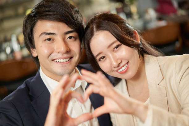 Asian couple making a heart symbol with their fingers