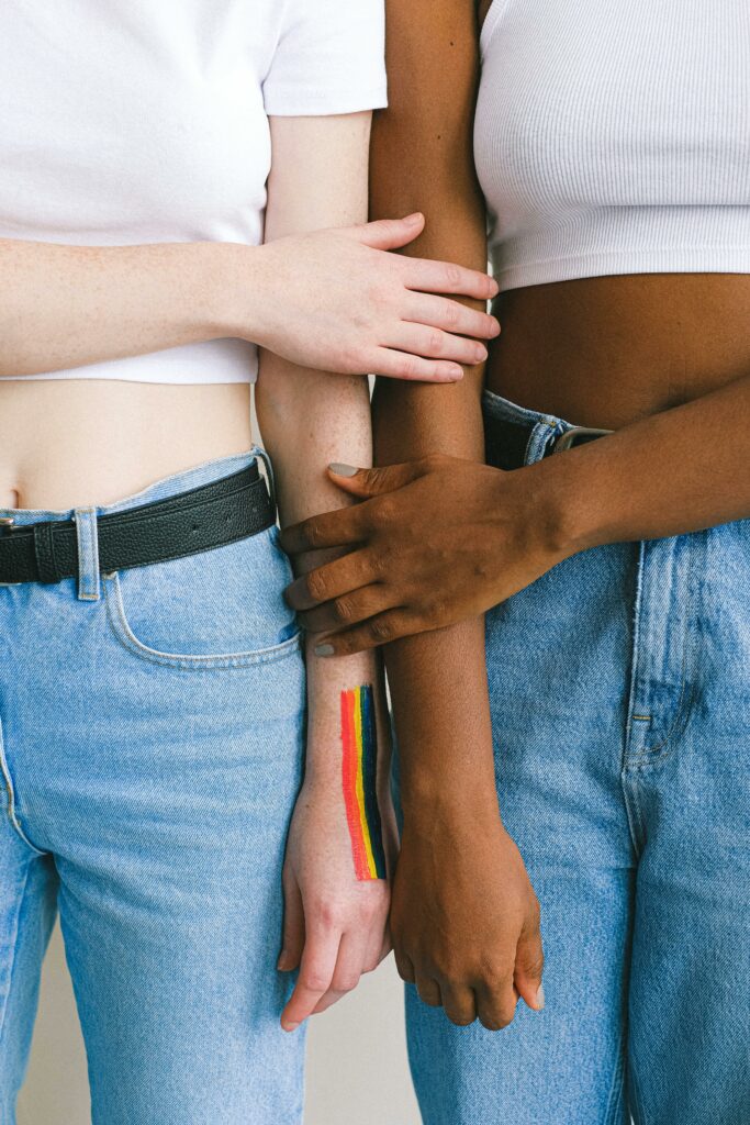 A black and white woman with their arms side by side with each other holding each others arm. overcoming cultural barriers in relationships