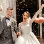 Happy wedding photography of bride and groom at wedding ceremony. Wedding tradition sprinkled with rice and grain