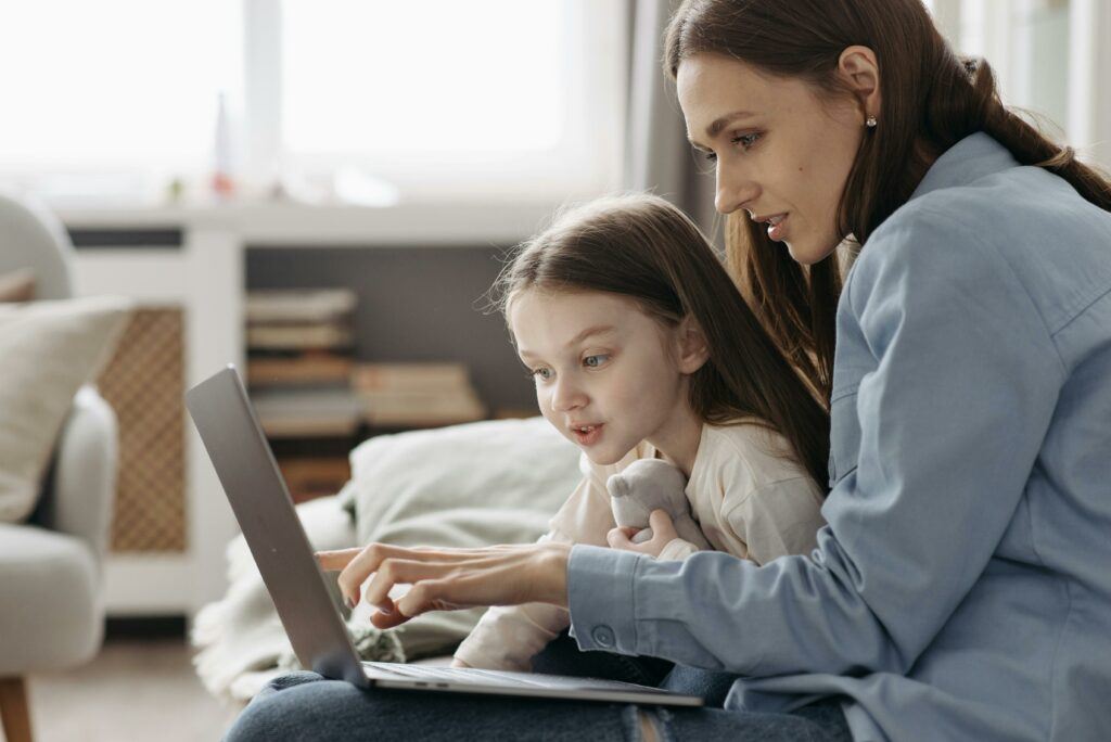 mom and daughter looking at a laptop. Managing the Pros and Cons of Digital Learning for Kids