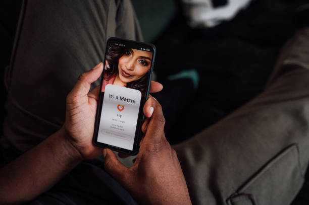 close up of hands holding a smartphone. The screen shows that he's matched with a young woman.
