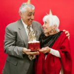 A couple holding their 50th Anniversary cake.