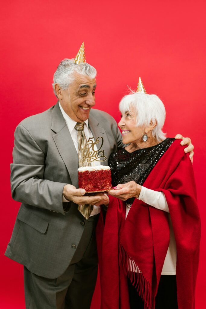 A couple holding their 50th Anniversary cake.