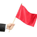 Hand holding a red flag isolated on white background. 10 Signs of a Emotionally Abusive Relationship